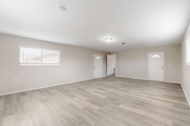 unfurnished living room with light wood-style flooring and baseboards