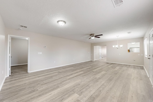 unfurnished room featuring visible vents, ceiling fan with notable chandelier, a textured ceiling, and light wood-style flooring