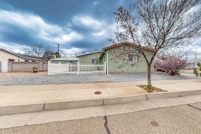 view of front of home with stucco siding and a fenced front yard