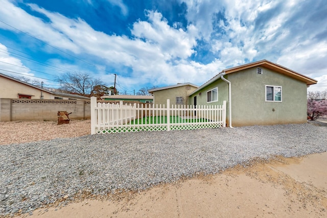 view of front of house featuring a fenced front yard and stucco siding