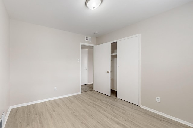 unfurnished bedroom with light wood-style flooring, baseboards, and visible vents