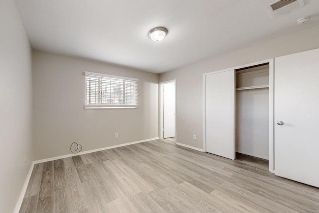 unfurnished bedroom with light wood finished floors, visible vents, and baseboards