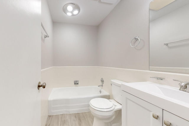 full bathroom featuring a bath, toilet, vanity, and wood finished floors