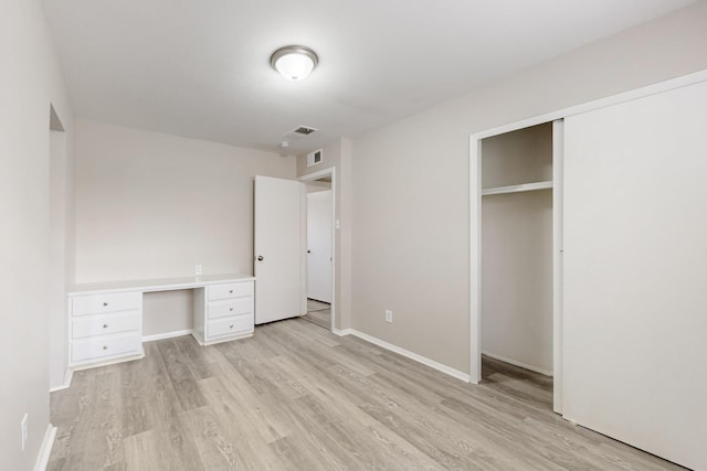 unfurnished bedroom featuring a closet, visible vents, light wood-style flooring, and baseboards