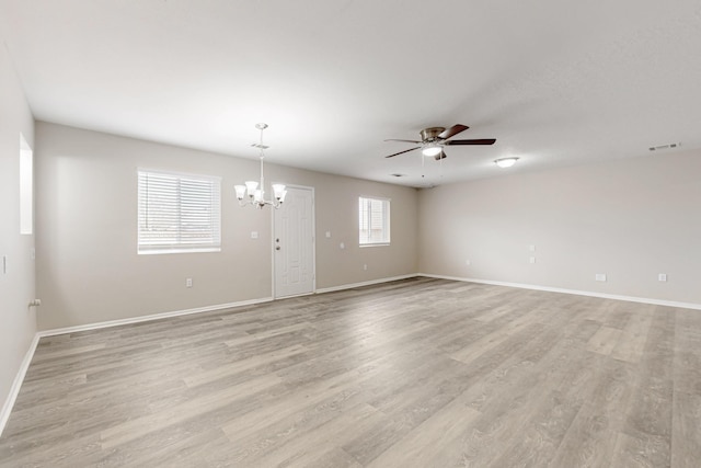 unfurnished living room with visible vents, baseboards, light wood-style floors, and ceiling fan with notable chandelier