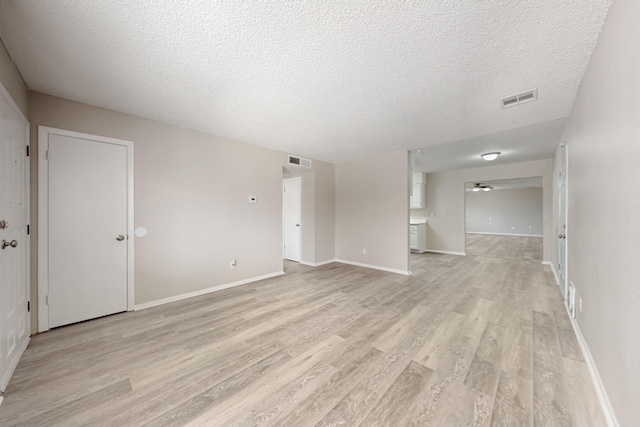 interior space with light wood finished floors, visible vents, and baseboards