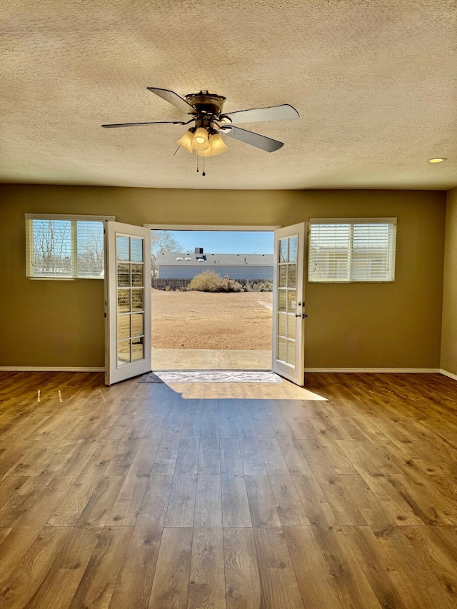 entryway featuring ceiling fan, baseboards, plenty of natural light, and wood finished floors