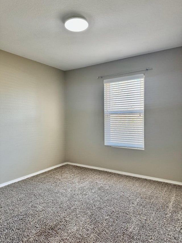 carpeted spare room with baseboards