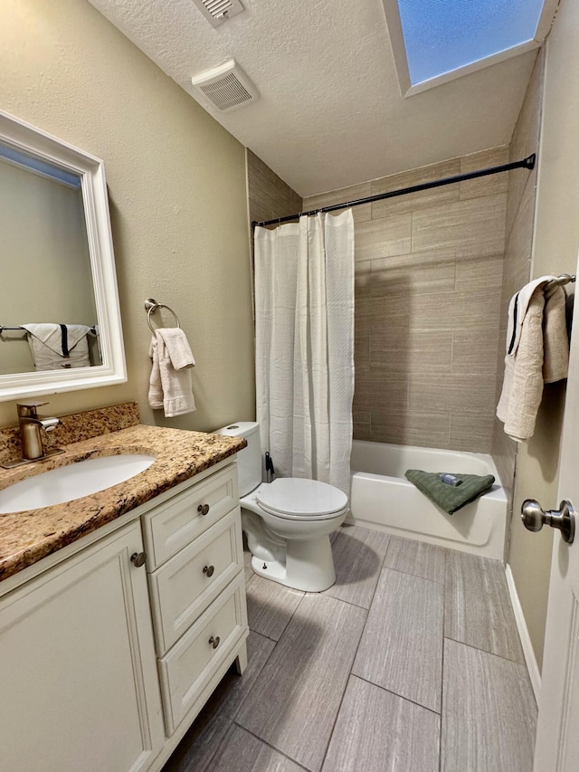 bathroom featuring vanity, visible vents, a textured ceiling, toilet, and shower / tub combo with curtain