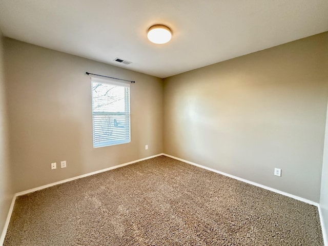 carpeted empty room featuring visible vents and baseboards