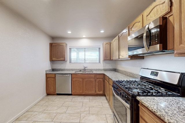 kitchen with light stone countertops, baseboards, recessed lighting, a sink, and appliances with stainless steel finishes