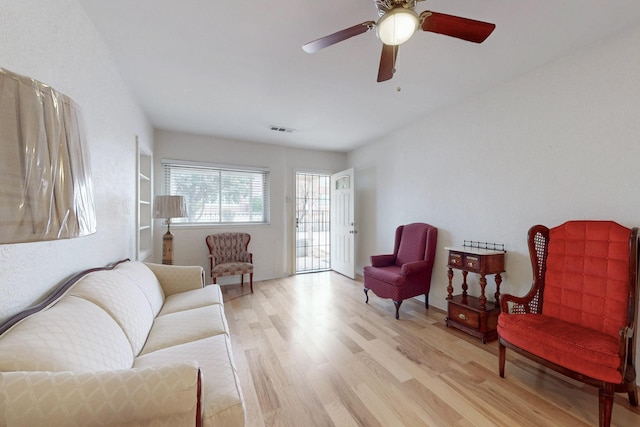 living area with visible vents, light wood-style flooring, and ceiling fan