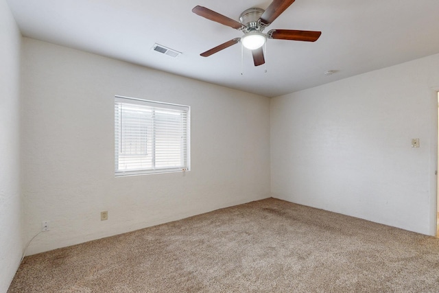 spare room featuring visible vents, carpet floors, and a ceiling fan