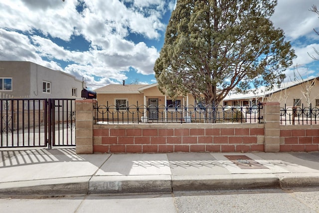 exterior space featuring a fenced front yard, stucco siding, and a gate