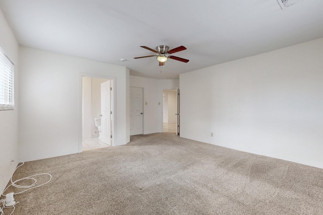 unfurnished room with light carpet and a ceiling fan