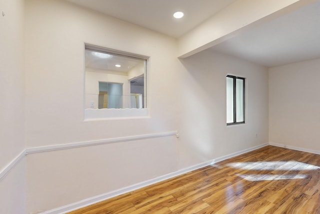 empty room with recessed lighting, wood finished floors, and baseboards