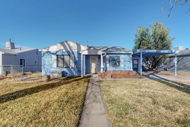 bungalow-style home featuring an attached carport, a front lawn, and fence