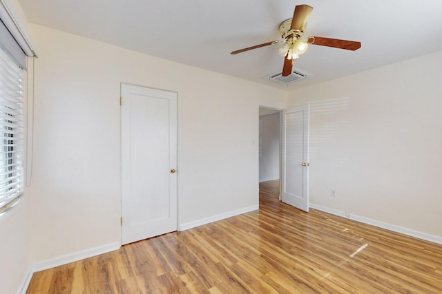 unfurnished bedroom featuring light wood finished floors, visible vents, a ceiling fan, and baseboards