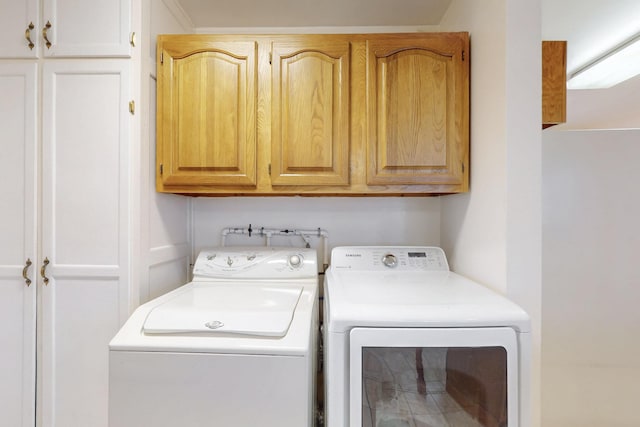 washroom featuring cabinet space and independent washer and dryer