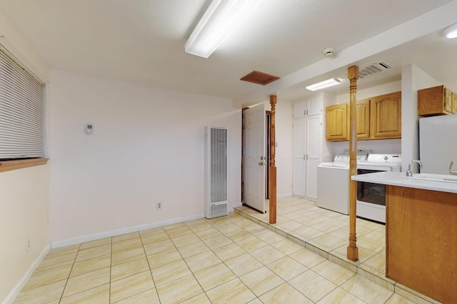 kitchen featuring visible vents, a sink, freestanding refrigerator, light tile patterned flooring, and light countertops