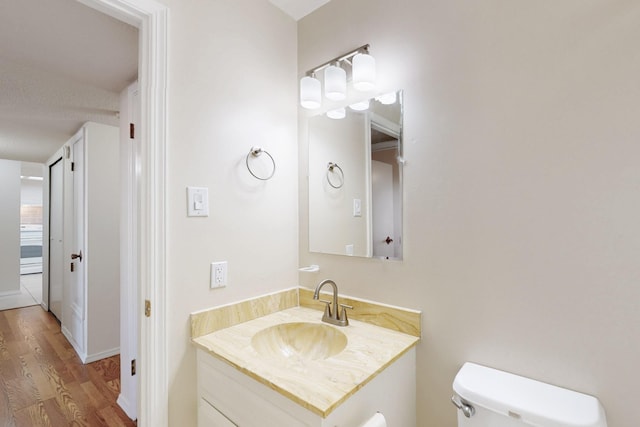 bathroom featuring toilet, wood finished floors, and vanity