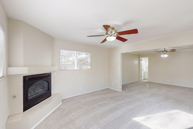 unfurnished living room with ceiling fan, baseboards, carpet, and a glass covered fireplace