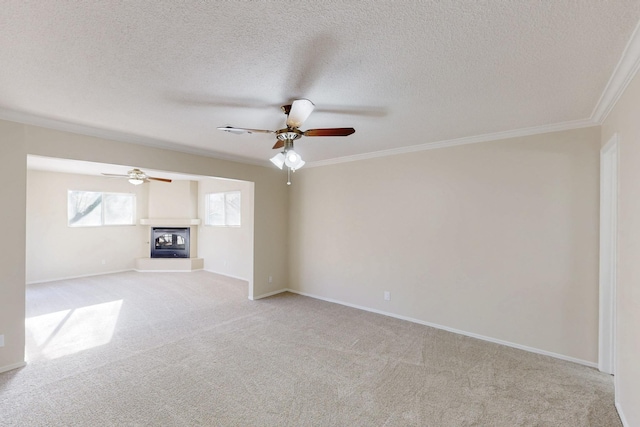 unfurnished living room featuring a multi sided fireplace, carpet, a ceiling fan, and ornamental molding