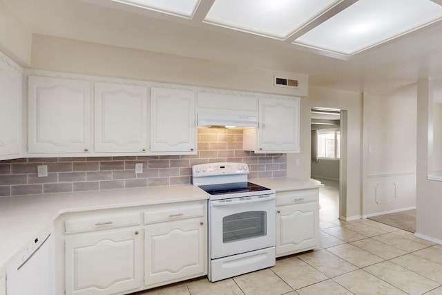 kitchen with white appliances, visible vents, white cabinets, under cabinet range hood, and backsplash