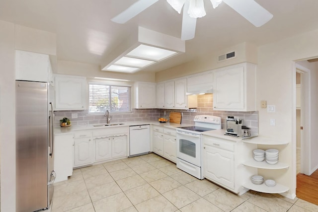 kitchen featuring backsplash, white appliances, open shelves, and a sink