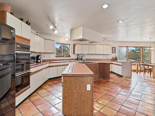 kitchen featuring custom exhaust hood, white cabinetry, a kitchen island, and dobule oven black