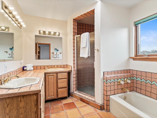 bathroom with double vanity, tile patterned flooring, a bath, and a sink