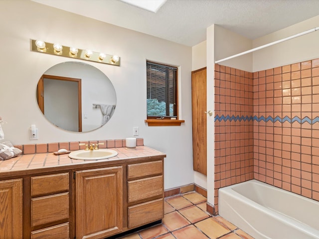 bathroom with vanity, washtub / shower combination, baseboards, a textured ceiling, and tile patterned floors