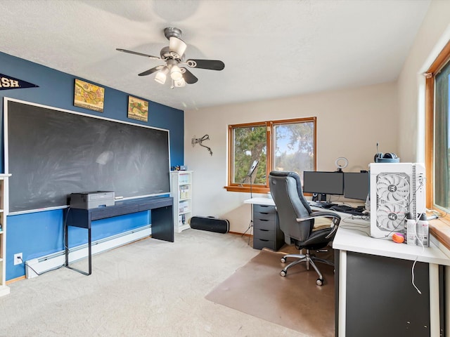 carpeted office space featuring baseboard heating and ceiling fan