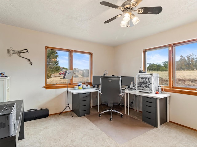 home office featuring light colored carpet, a textured ceiling, and baseboards