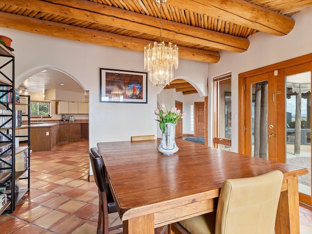 dining space featuring beam ceiling, wooden ceiling, arched walkways, and a chandelier