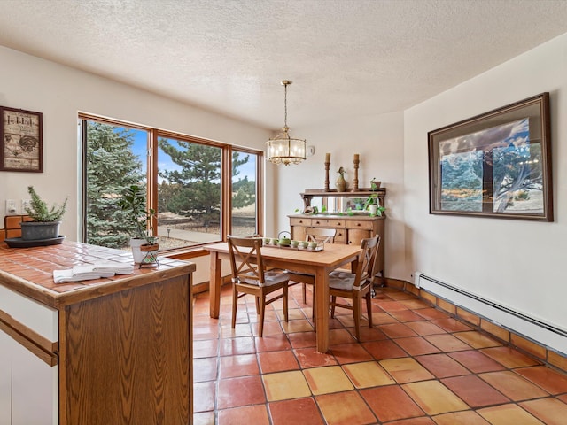 dining room with light tile patterned flooring, a notable chandelier, a textured ceiling, and baseboard heating