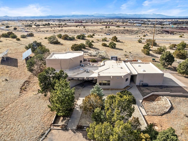 birds eye view of property with view of desert and a mountain view