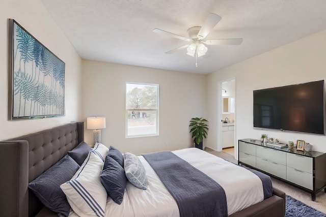 bedroom featuring light colored carpet, connected bathroom, and ceiling fan