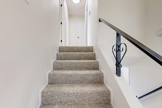 stairs featuring baseboards and carpet