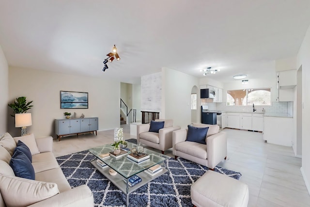 living room with stairway and arched walkways