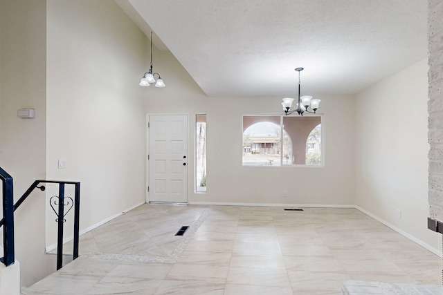 entryway featuring a notable chandelier, visible vents, high vaulted ceiling, and baseboards