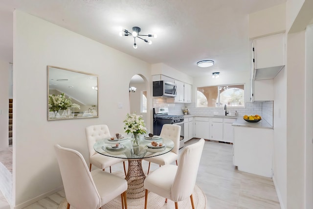 dining room featuring baseboards and arched walkways