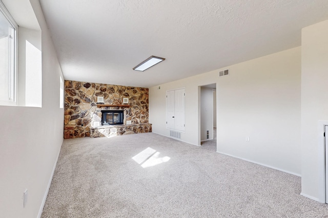 unfurnished living room featuring carpet flooring, a fireplace, and visible vents