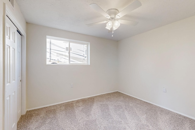 unfurnished bedroom featuring a closet, baseboards, ceiling fan, and carpet flooring