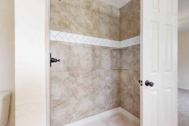 full bathroom featuring toilet and tiled shower