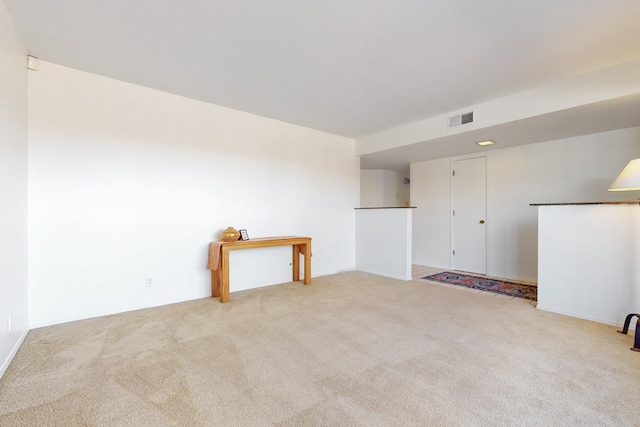 empty room featuring visible vents and light carpet