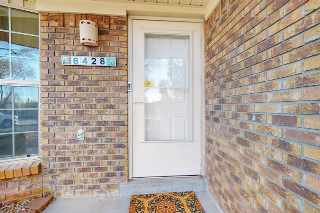 view of exterior entry featuring brick siding