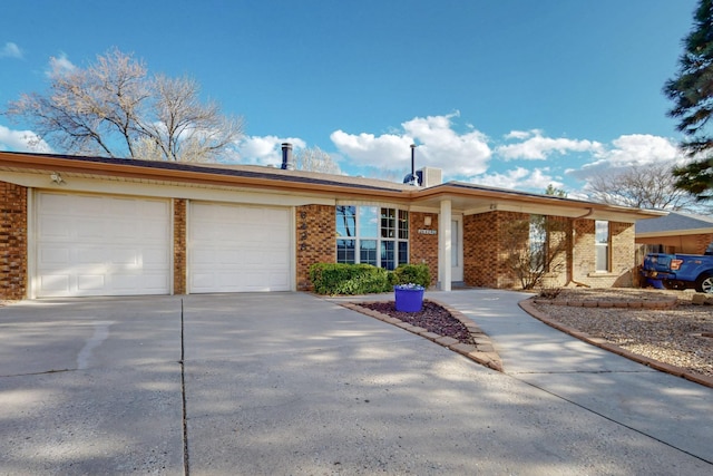 ranch-style home with a garage, brick siding, and concrete driveway