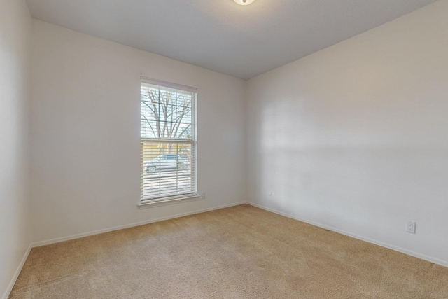 empty room with baseboards and light carpet