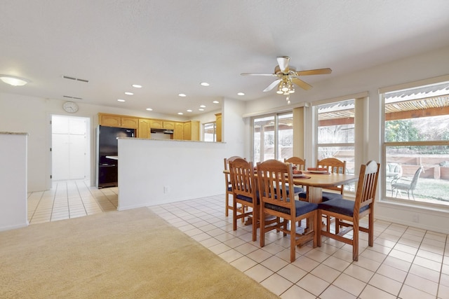 dining room with ceiling fan, light tile patterned floors, plenty of natural light, and light carpet